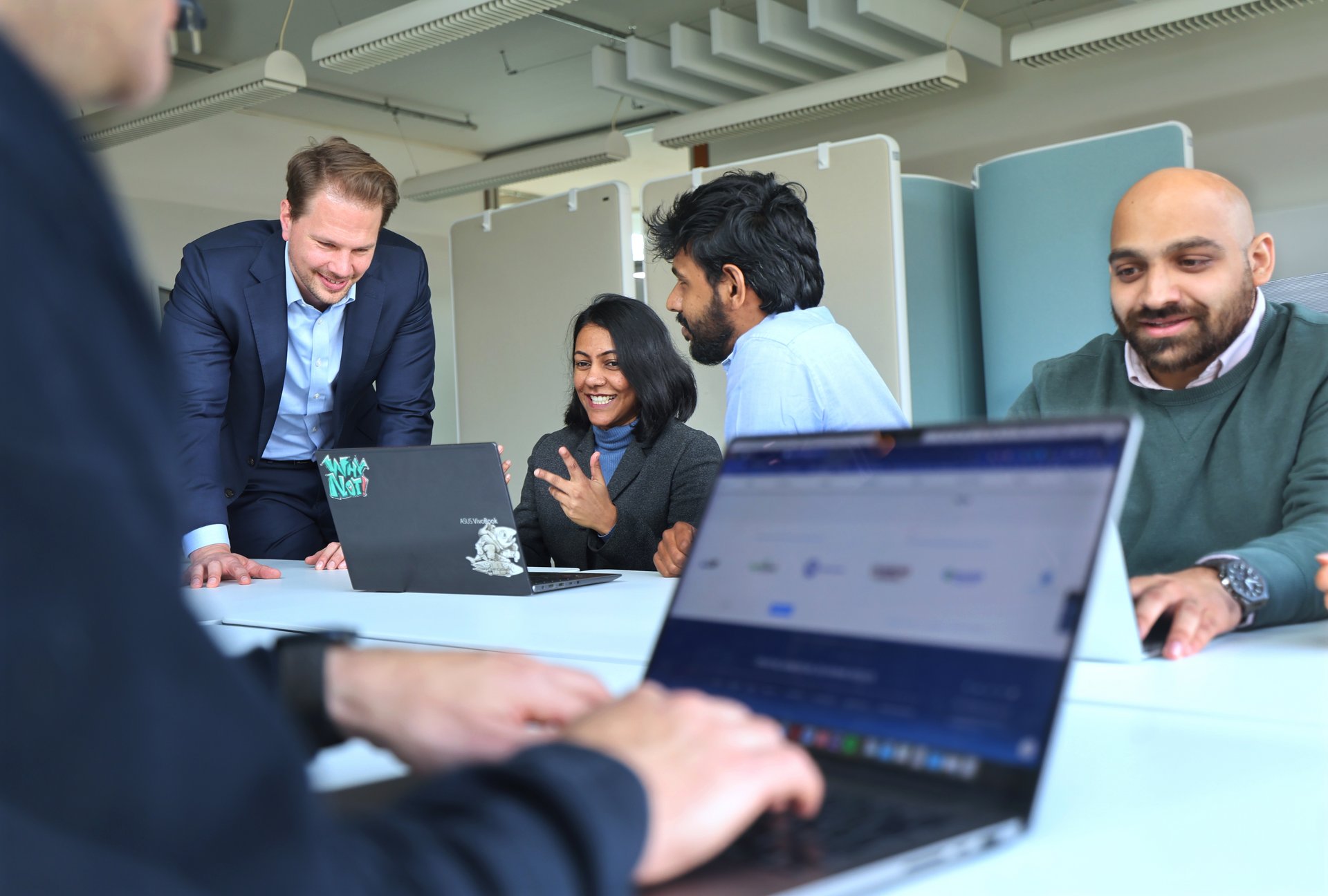 Im Seminarraum: Menschen arbeiten an Laptops, bzw, sind miteinander im Gespräch