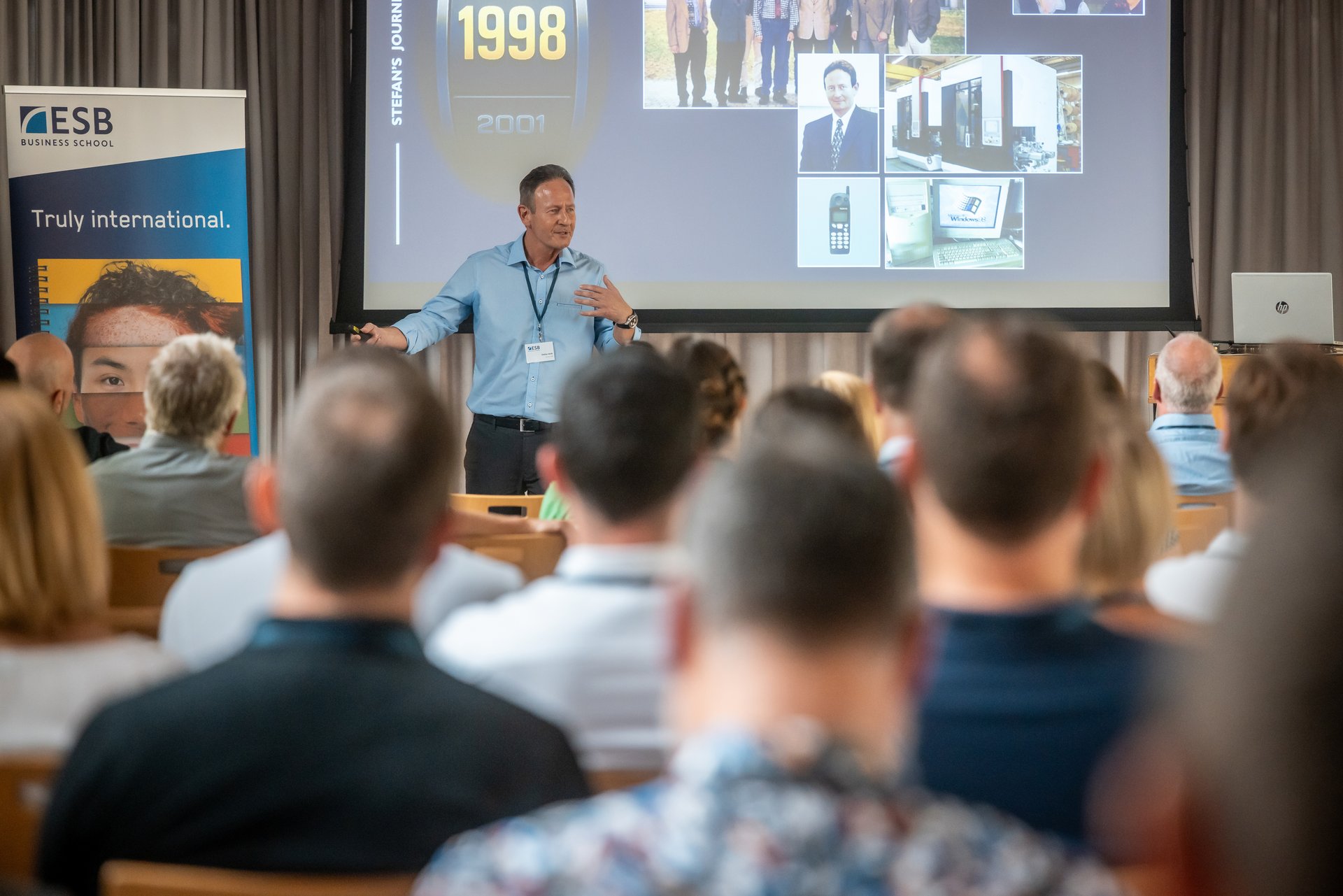 Ein Alumnus präsentiert vor sitzendem Publikum Eindrücke aus 30 Jahren MBA International Management Part-Time